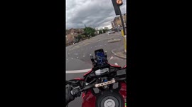 Cyclist nearly crashes into motorcycle at intersection in London, England, UK