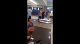 Toddler scores basketball shot from stair handrail at mall