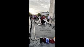 Man lights cigarette using eternal flame at Arc de Triomphe in Paris, France