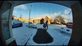 Girl slips while dragging rubbish bin on snowy driveway but quickly gets back up