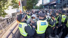 Police scuffle with anti fascists and make an arrest during anti migrant protest in Canary Wharf