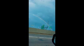 Full-size rainbow spotted near highway exit in Clarksville, Indiana