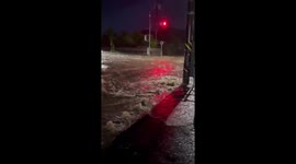 Vehicles struggle to navigate flooded road in Aira, Kagoshima