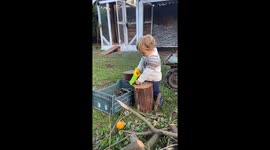 Toddler playfully pretends to saw wood in Sapucaia do Sul, Brazil