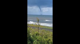 Waterspout tornado seen on the horizon above sea in Japan