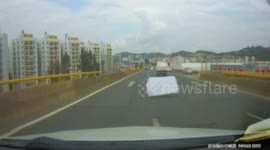 Car narrowly avoids sofa dropped by truck