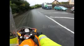 Biker crashes and slides on wet road