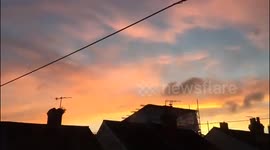 Slow motion of the sun setting over houses