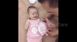 Baby laughs when he looks at dad counting money