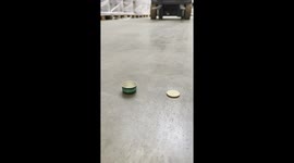 Skilled forklift driver picks up small coin and places it into tiny bottle cap