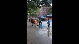Children play under fire hydrant waterfall in New York City, New York, USA