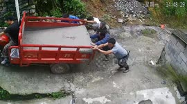 Cement spills during uphill tricycle push in Guizhou, China
