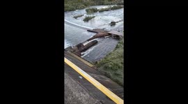 Vehicle navigates slippery Blangue Dam bridge safely in Sao Francisco de Paula, Brazil
