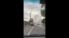 Woman on her way to work drives past busted pipe spouting water like a fountain
