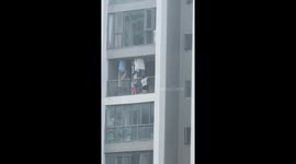 Two children seen climbing over balcony on high rise apartment block