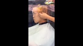 Barber uses clips to pin back customer's ears in Inner Mongolia, China