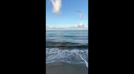 Powerful surf and rough waves crash ashore on a clear day in Florida, USA