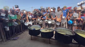 Displaced Palestinians in Gaza line up for hot meals amid hunger crisis