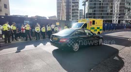 An anti illegal immigrant protestor is taken to an ambulance after getting heat stroke as he protested outside the Britannia Hotel in Canary Wharf