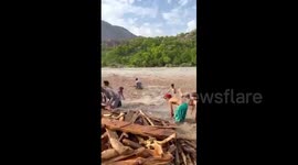 Pakistan: Children Collecting Driftwood Brought by Floodwaters in Gilgit-Baltistan