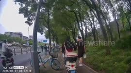 Scooter rider falls while avoiding pedestrian and man beside bicycle in Shanghai, China