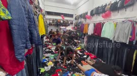 Crazed bargain hunters race into second hand clothes shop at opening time