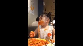 Toddler gets covered in sauce while eating spaghetti at restaurant
