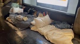 Homeless person has sign threatening to break people’s umbrellas if they drip water on his bed in Sydney, Australia