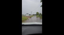 Man struggles with motorcycle in floodwaters in Khon Kaen Thailand
