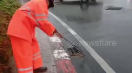 Brave policeman catches python washed onto road during storm