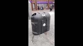 Rubbish bin on fire caused by cigarette butts in Waltham Station Square, London, UK.