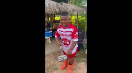 Boy learning to cook misses while dropping fish into frying pan