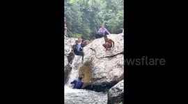 Boy trapped in raging current between rocks rescued after crowd form human wall