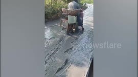 Elderly man rides his motorcycle onto freshly poured cement