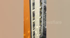 Housewife washes 27th-floor windows while balancing on ledge