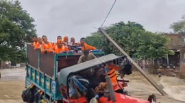 Tractor trailer rescuing residents from flood overturns dumping them in water