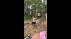 Dad and Stepson Laughing and Slipping on a Sandy Hill