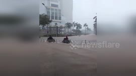 Motorcyclists Struggle Through Waist-Deep Water On Flooded Streets In Hanoi