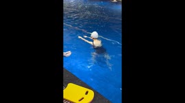Beginner swimmer splashes bystander in pool