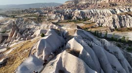 Tourists ride through Türkiye's Cappadocia as iconic balloons rise at sunrise