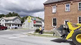 Heavy Pay Loader driving thru town to move some dirt on Main Street