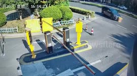 Car drags road barriers under bumper as driver tries to enter building