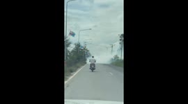 Motorcycle rider braves smoke engulfing road narrowly avoiding oncoming truck