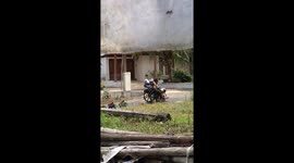 Grandfather rides wheelchair with toy trucks on slope in Sleman, Yogyakarta