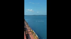 Helicopter delivers maritime pilot onto cargo ship to navigate difficult sea