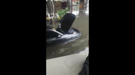 Drivers sit on the roofs of their cars as floods hit Philippine capital