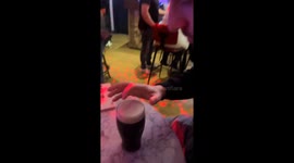 Foam face appears on a pint of Guinness after boy blows air at the beer