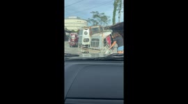 Kind driver helps push stranded tricycle off protruding metal pipe on road