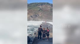 Dramatic moment two people swept away by crashing waves