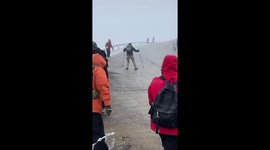 Hiker slips as he slides uncontrollably down icy mountain road